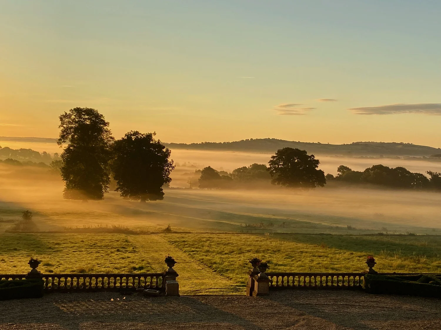 Long lawns and mature trees in the private Somerset grounds